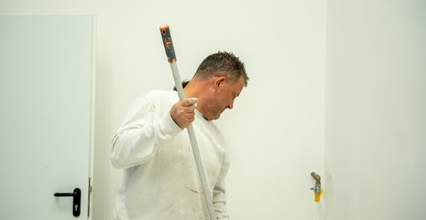 Maler mit Farbrolle beim Streichen einer Innenwand – Maler Quantius Innenanstrich